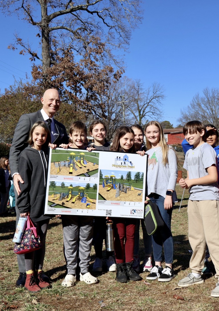 Principal posing for a picture with his students